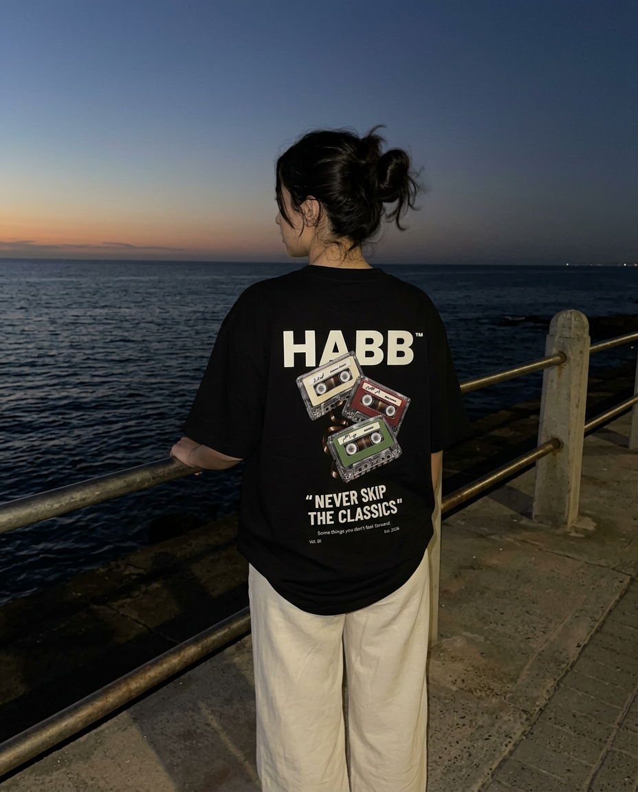 Wearing The Classics Tee in Black by the sea